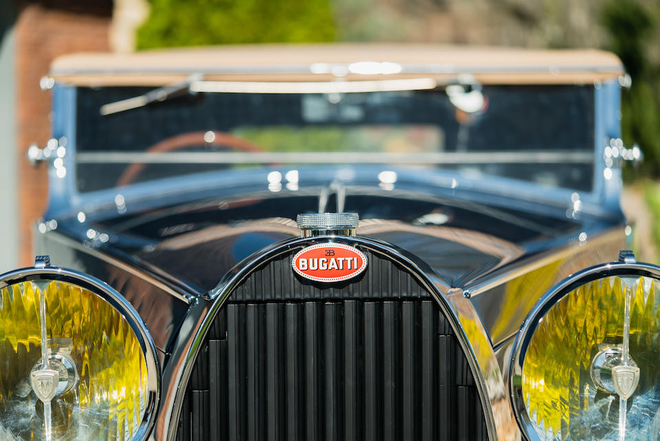 Close up of 1934 Bugatti Type 57, with signature red marque plate and headlamps. Lease a new or vintage Bugatti with Premier's Simple Lease today!