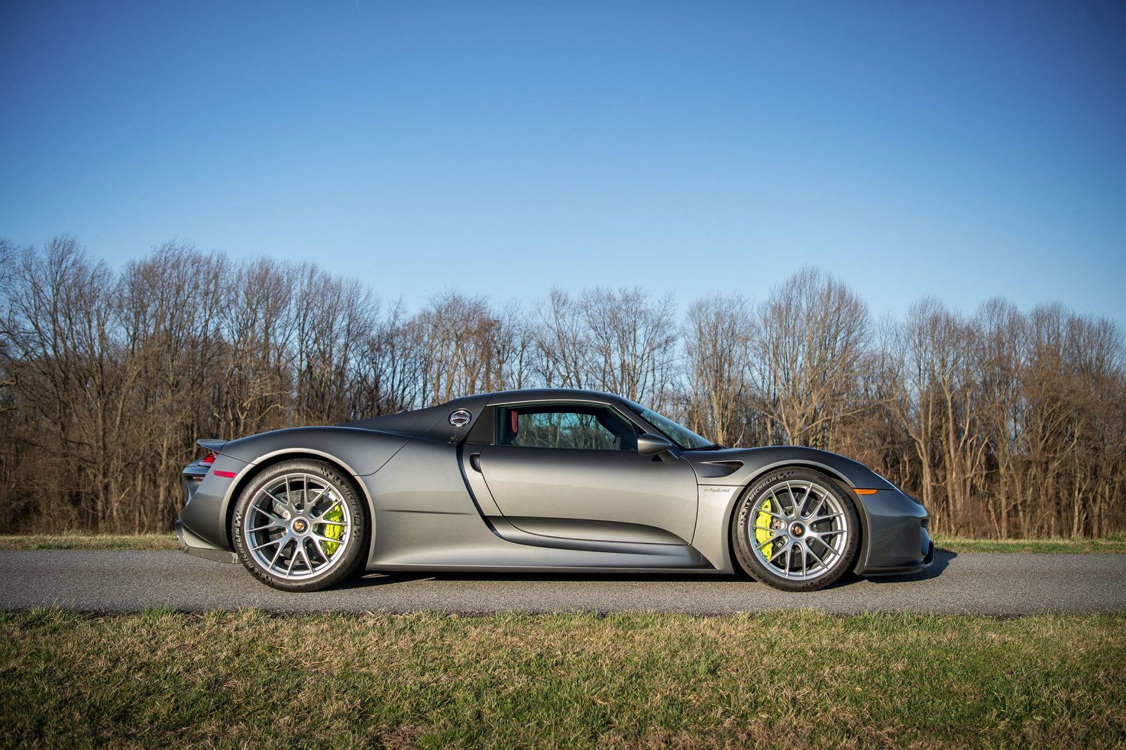 Silver Porsche 918 Spyder profile side view - against early spring trees; #pfs_leasing