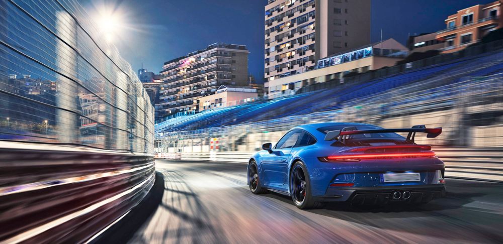 Blue 2022 Porsche 911 GT3 on track, profile view