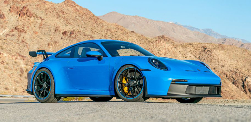 Blue 2022 Porsche 911 GT3 in desert setting.