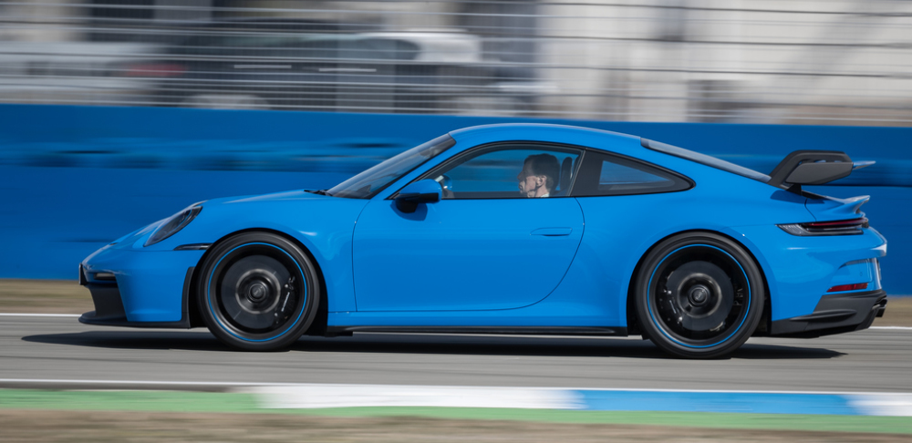 Blue 2022 Porsche 911 GT3 on track, profile view