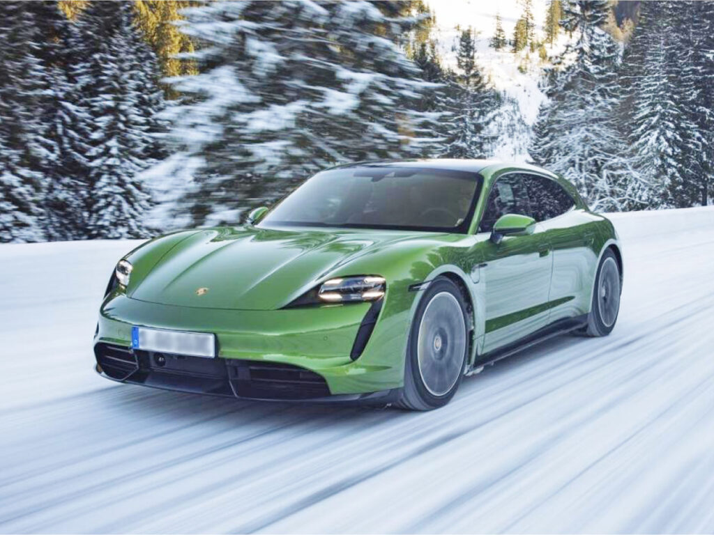 Green Porsche Taycan on snow-covered road