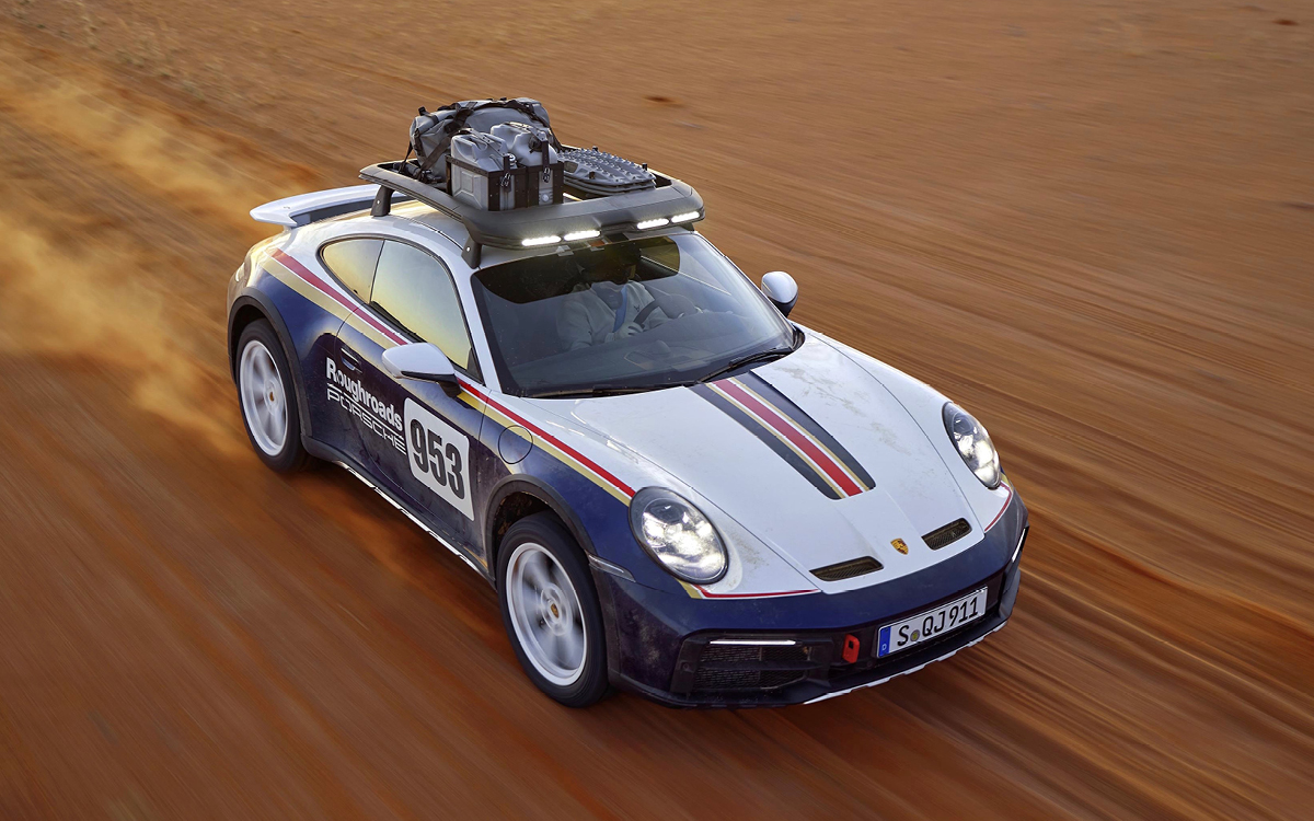 Blue and white 2023 Porsche 911 Dakar driving in desert, high view