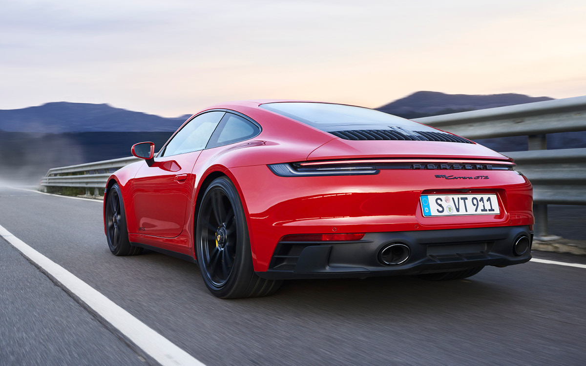 Red Porsche 911 Carrera GTS on road, rear view