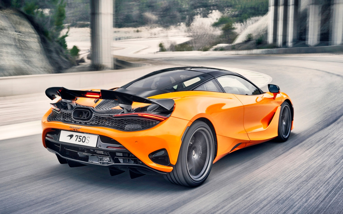 Orange McLaren 750S on road, left rear view