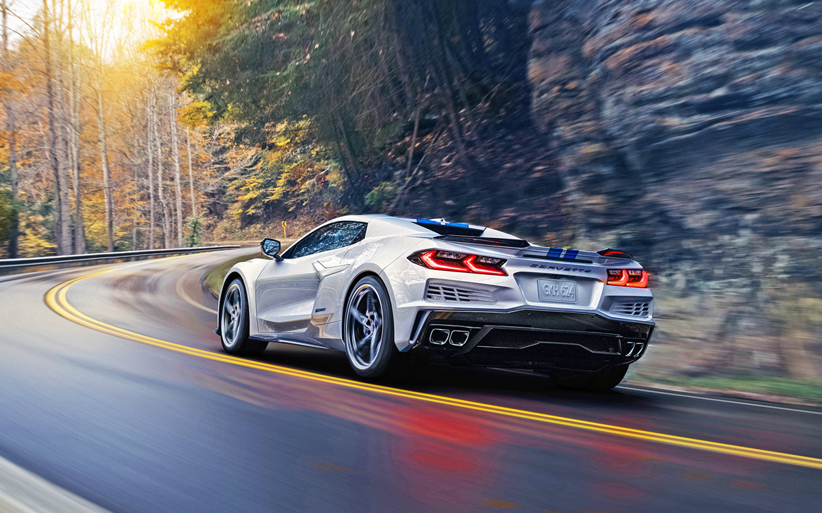 Silver Corvette E-Ray on country road, rear view.