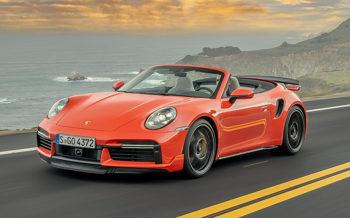 Orange Porsche 911 Turbo S Cabriolet on road, front view