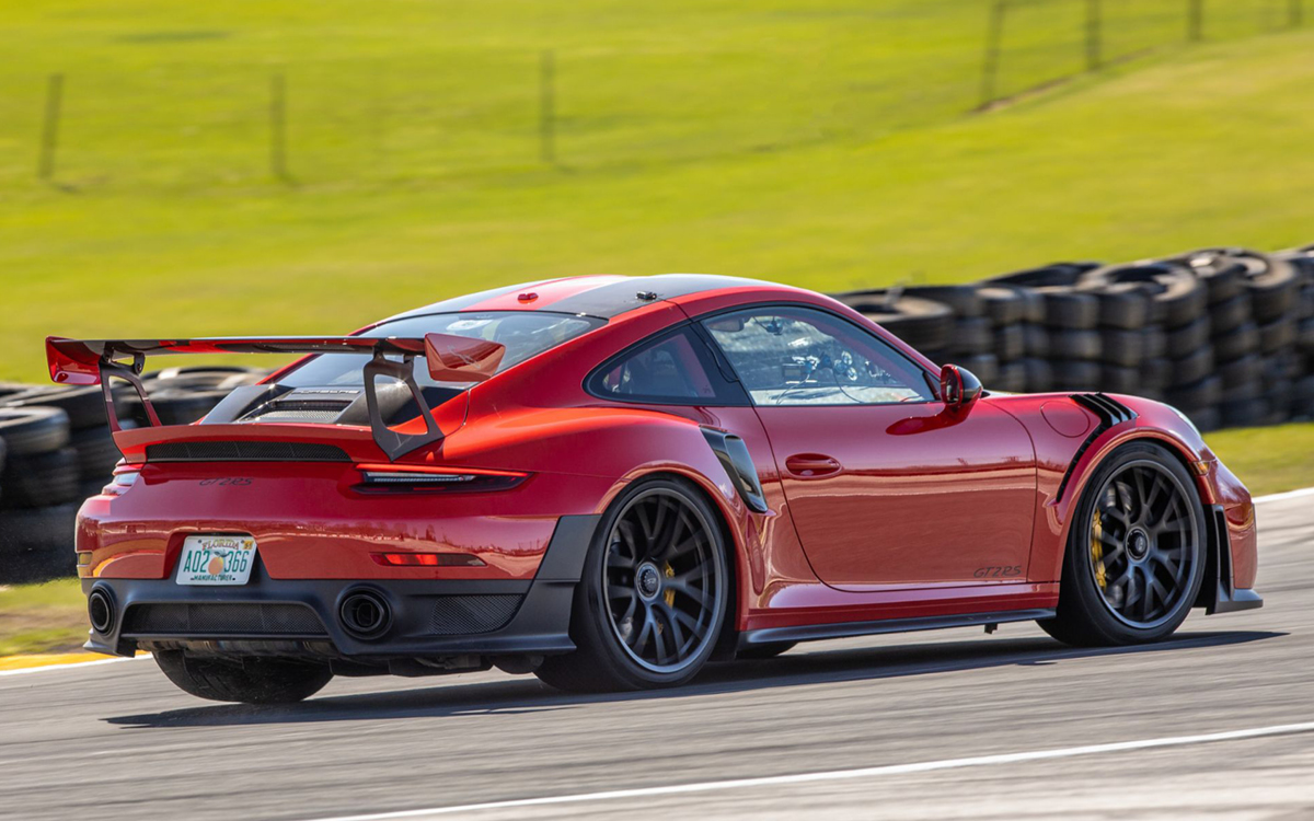 Red Porsche 911 GT2 RS on racetrack, rear view