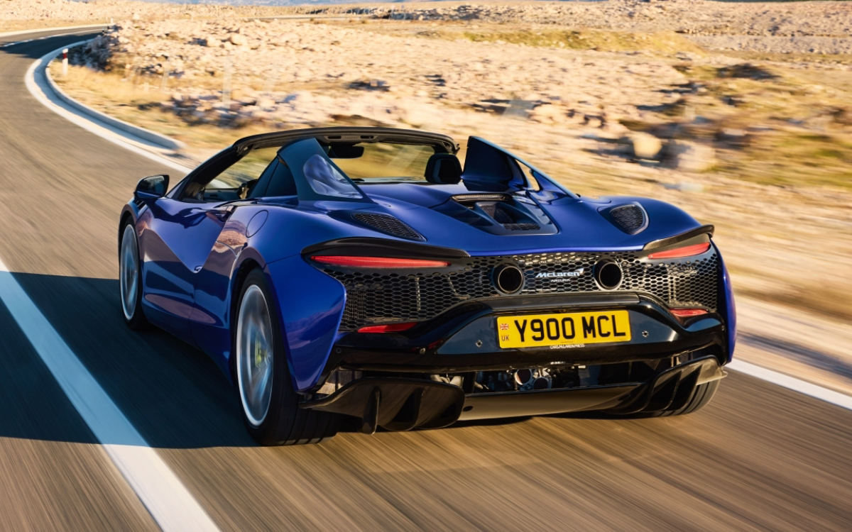 Blue McLaren Artura Spider on road rear view